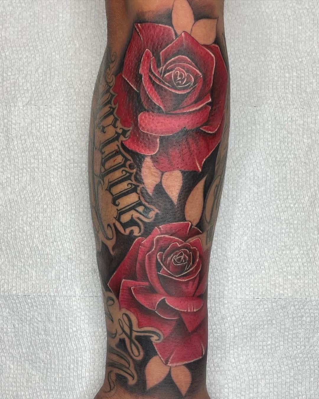 Rose, lettering and garden roses tattoo on the forearm, Chicano style, by Inksane Shorty in Austin, TX