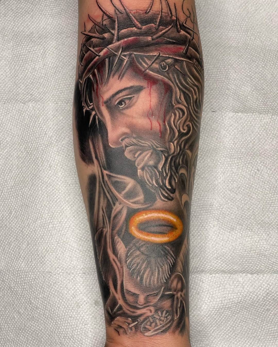 Jesus, crown of thorn and halo tattoo on the forearm, half sleeve, Chicano style, by Inksane Shorty in Austin, TX
