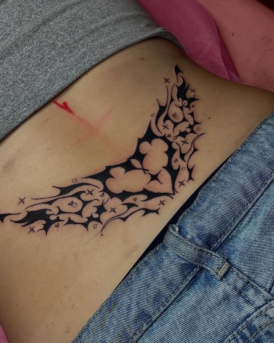 Cloud, star and temporary tattoo on the lower back, Cyber-tribal style, by Emma in Austin, TX