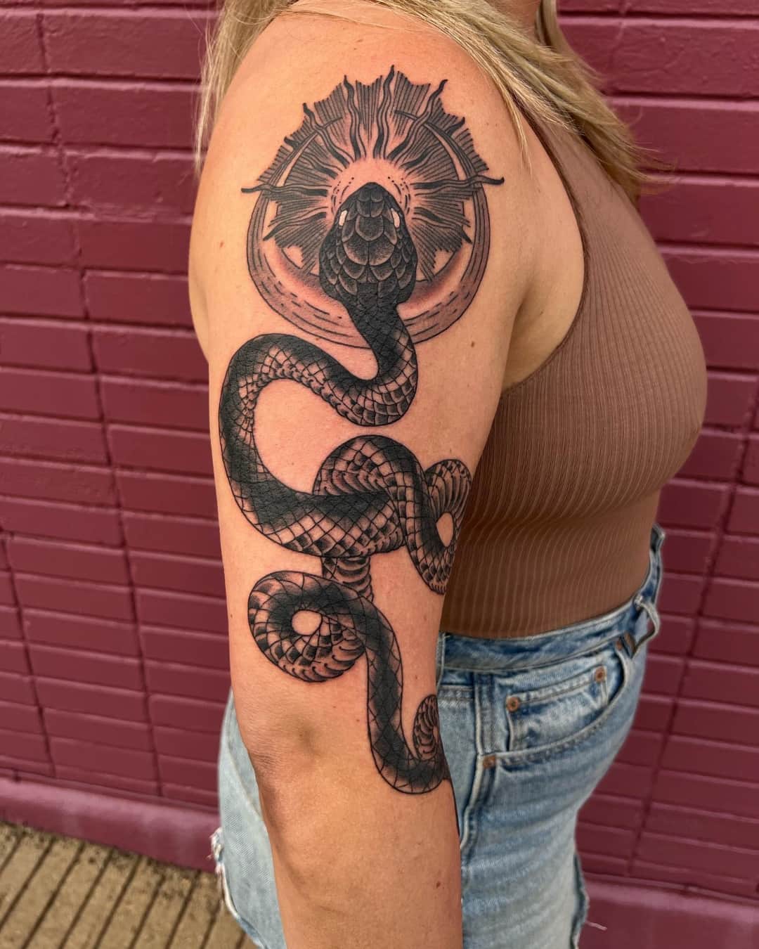Snake and sun tattoo on the upper arm, large piece, Illustrative style, by Donny Newman in Austin, TX