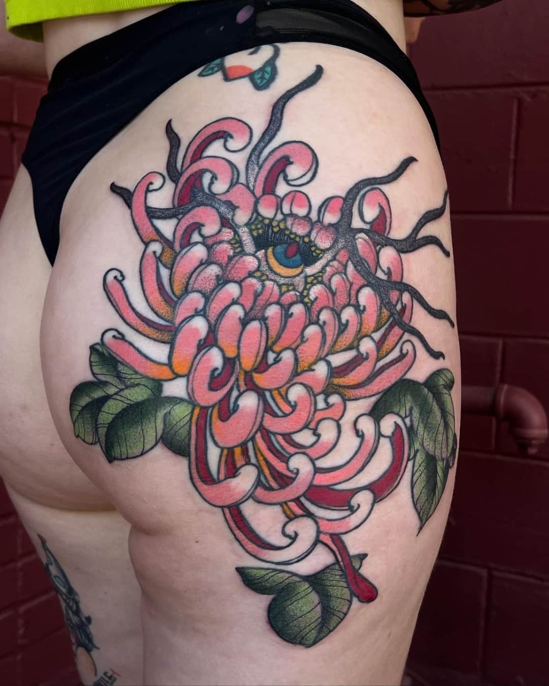 Small chrysanthemum, octopus and leaf tattoo on the thigh, Illustrative style, by Donny Newman in Austin, TX
