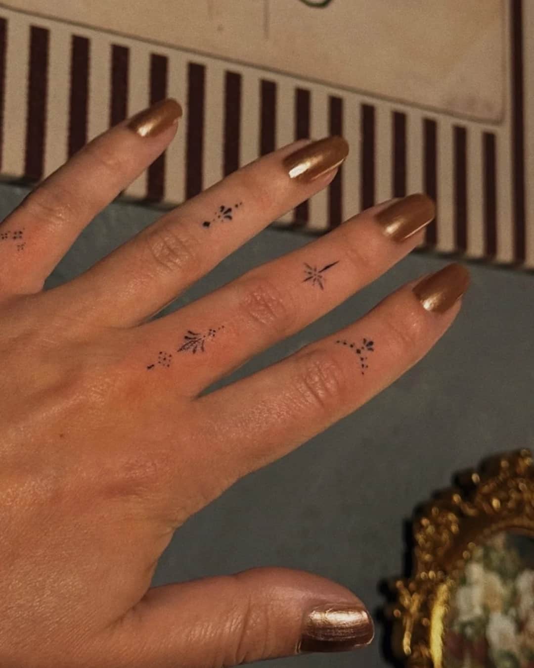 Small star tattoo on the fingers, Ornamental style, by Luisa Duarte in Austin, TX
