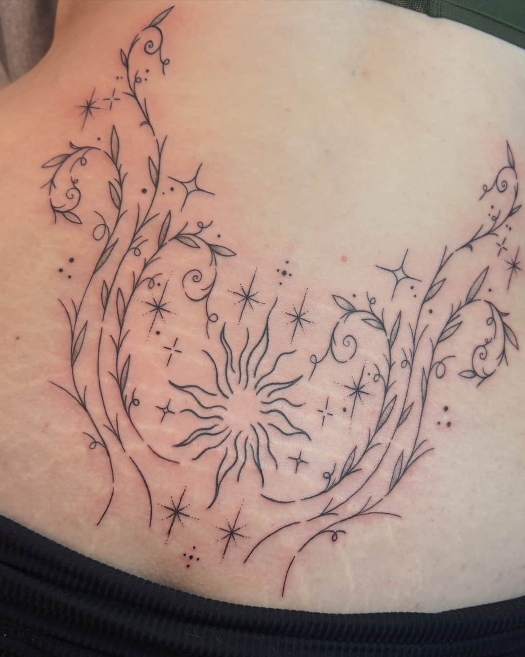 Sun, star and leaf tattoo on the lower back, Ornamental style, by Emma in Austin, TX