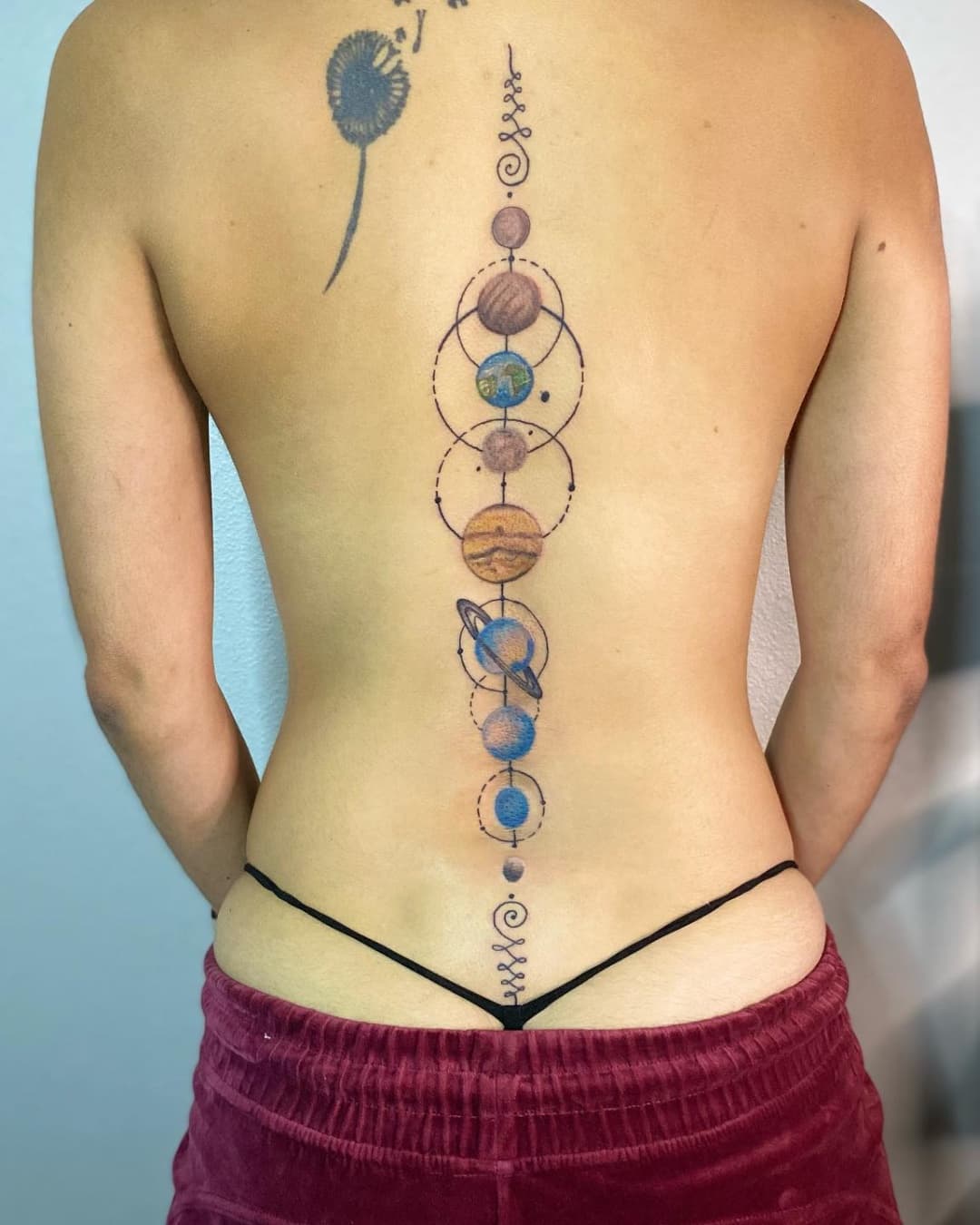 Planet, solar system, dandelion and flower tattoo on the spine, Geometric style, by Inksane Shorty in Austin, TX
